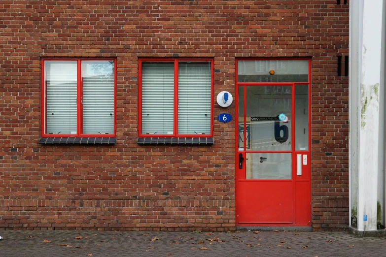 a red door sits in front of a brick building