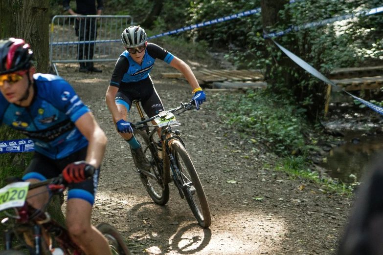 a man riding on the back of a bike down a dirt road