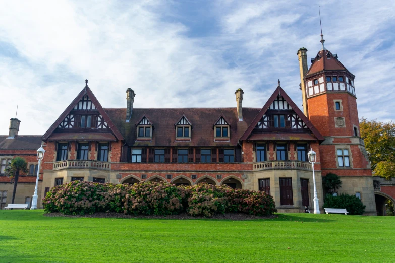 a large brick house with tall windows and a garden