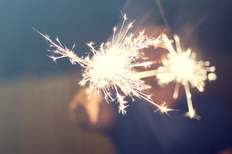 someone holding a firework in their hand and looking into it