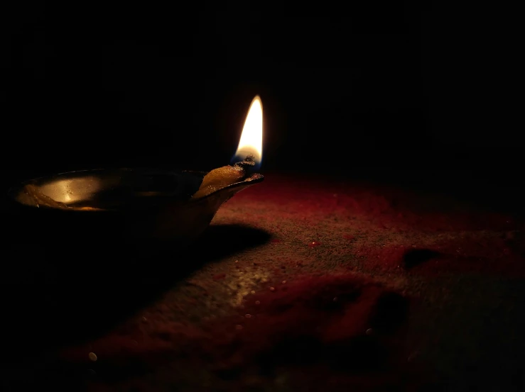 the single burning candle is seen in the dark