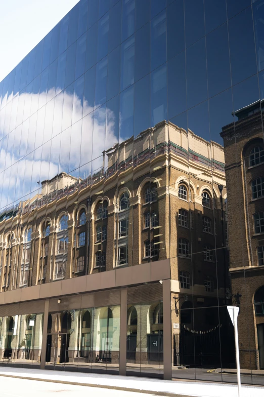 a tall building is reflected in the windows of another building