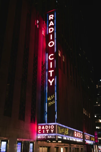 the radio city sign with neon lights is lit up