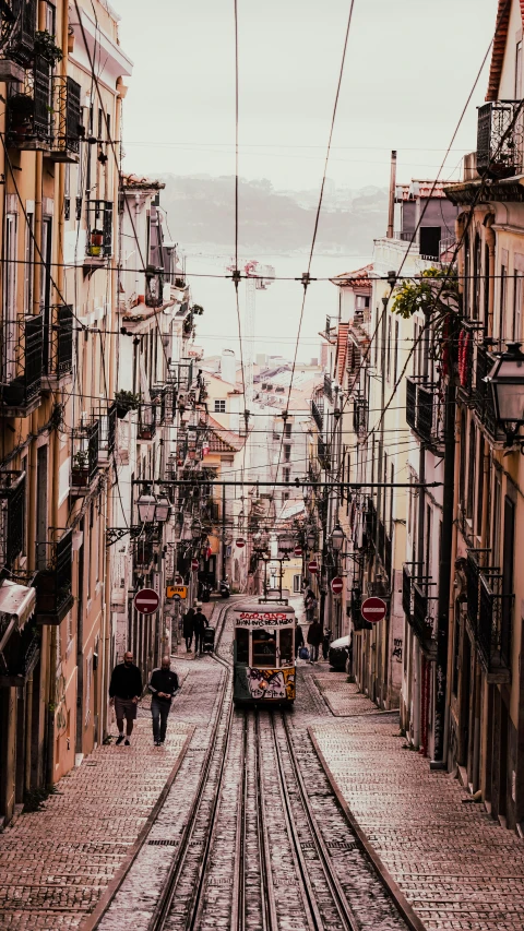 a city street that has a train going down it