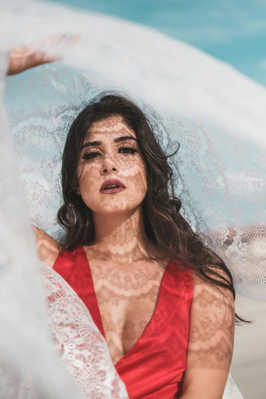 a beautiful young woman under an umbrella on the beach