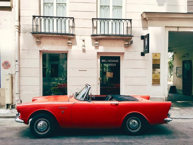 an old fashioned convertible with top down on the street