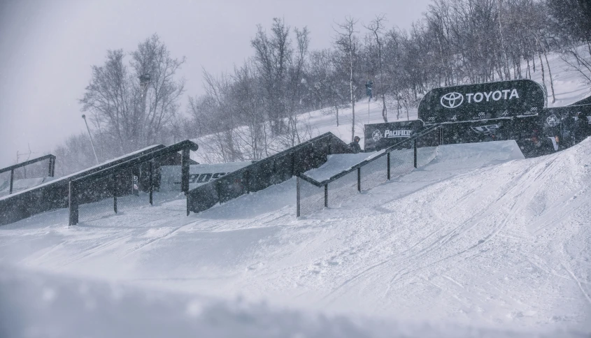 a group of three snow boarders riding down a hill