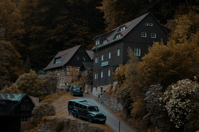 an rv drives down a steep road past a wood - framed building