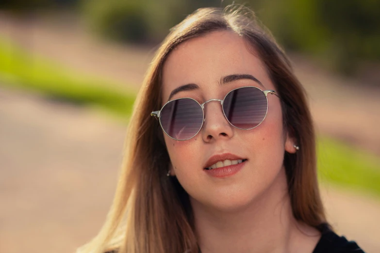 the woman is wearing sunglasses in front of the camera