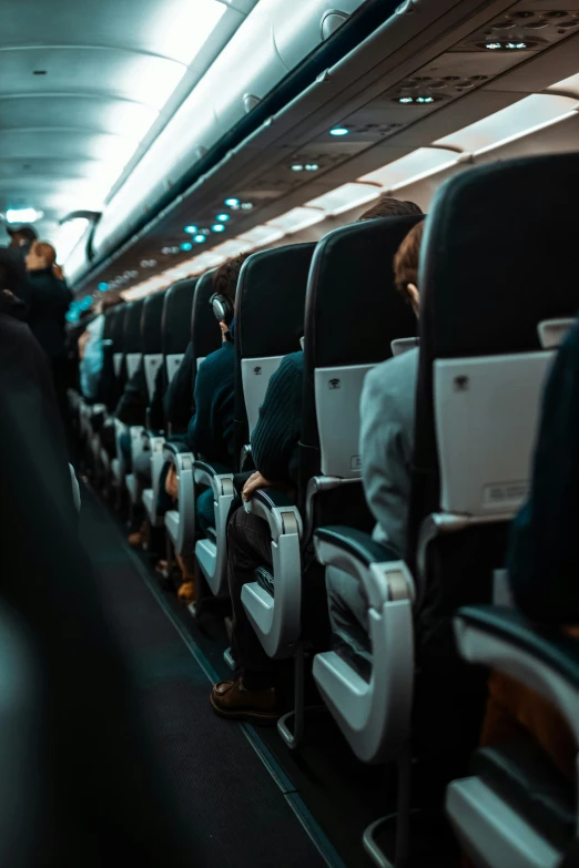 seats inside an airplane with many people sitting