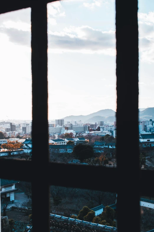 a view of a city and mountains from outside a window