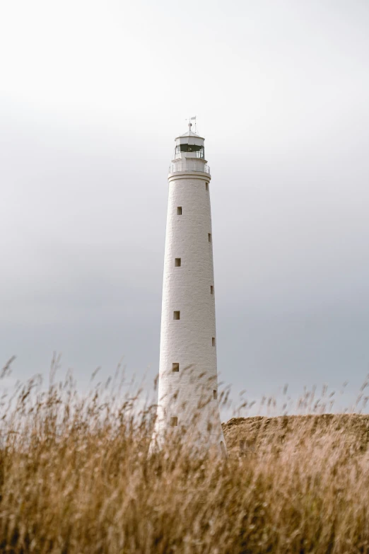 a light house is shown with a cloudy sky behind it