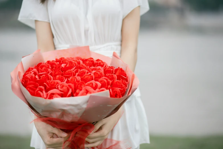 someone holding a red bunch of flowers in their hands