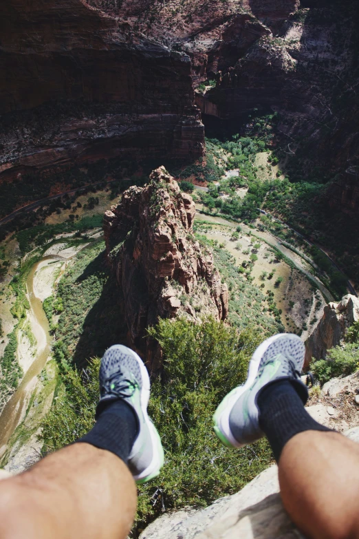 person standing on top of a large rock and looking down