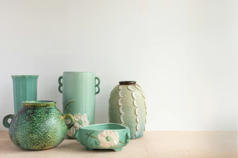 five green vases lined up side by side