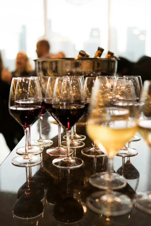 a number of wine glasses with many wine on a counter