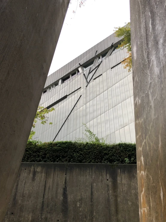 a large office building is shown through the corner of two cement columns