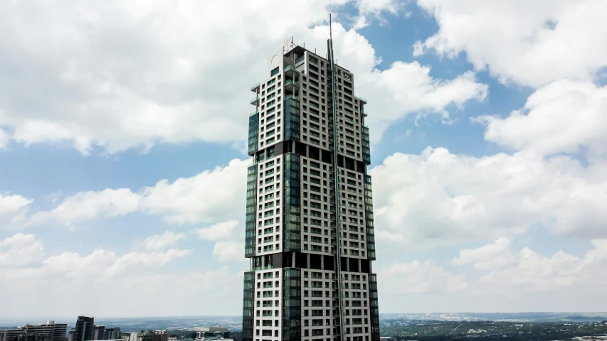 tall building sitting on top of a hill under a cloudy sky