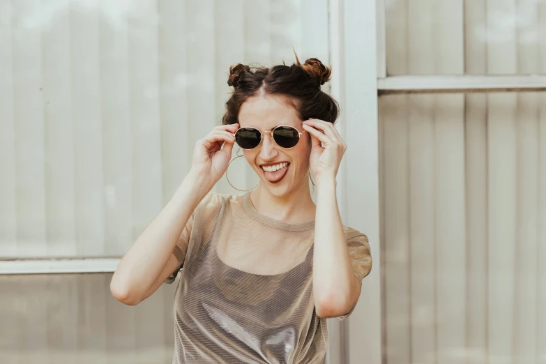 a young lady smiles for a picture wearing sun glasses