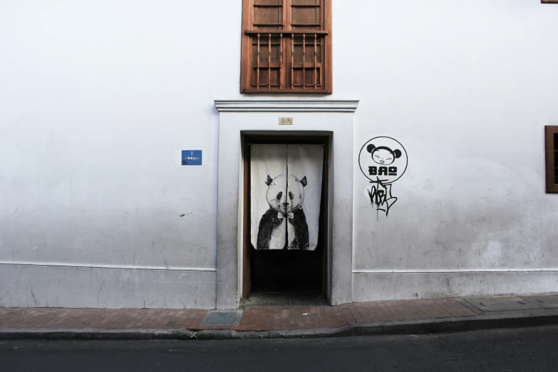 a tall white building has a doorway and window