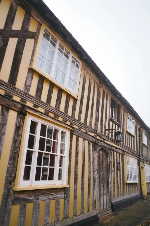 the facade of a house is covered in yellow and gray striped paint