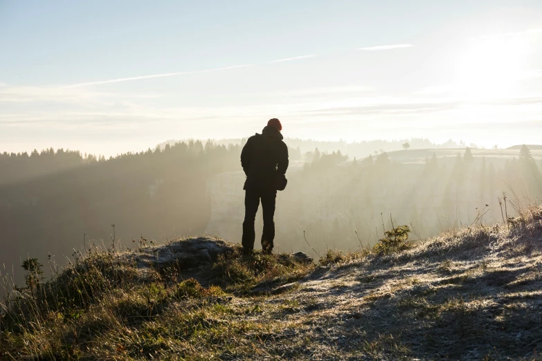 man on top of the mountain watching the sun set