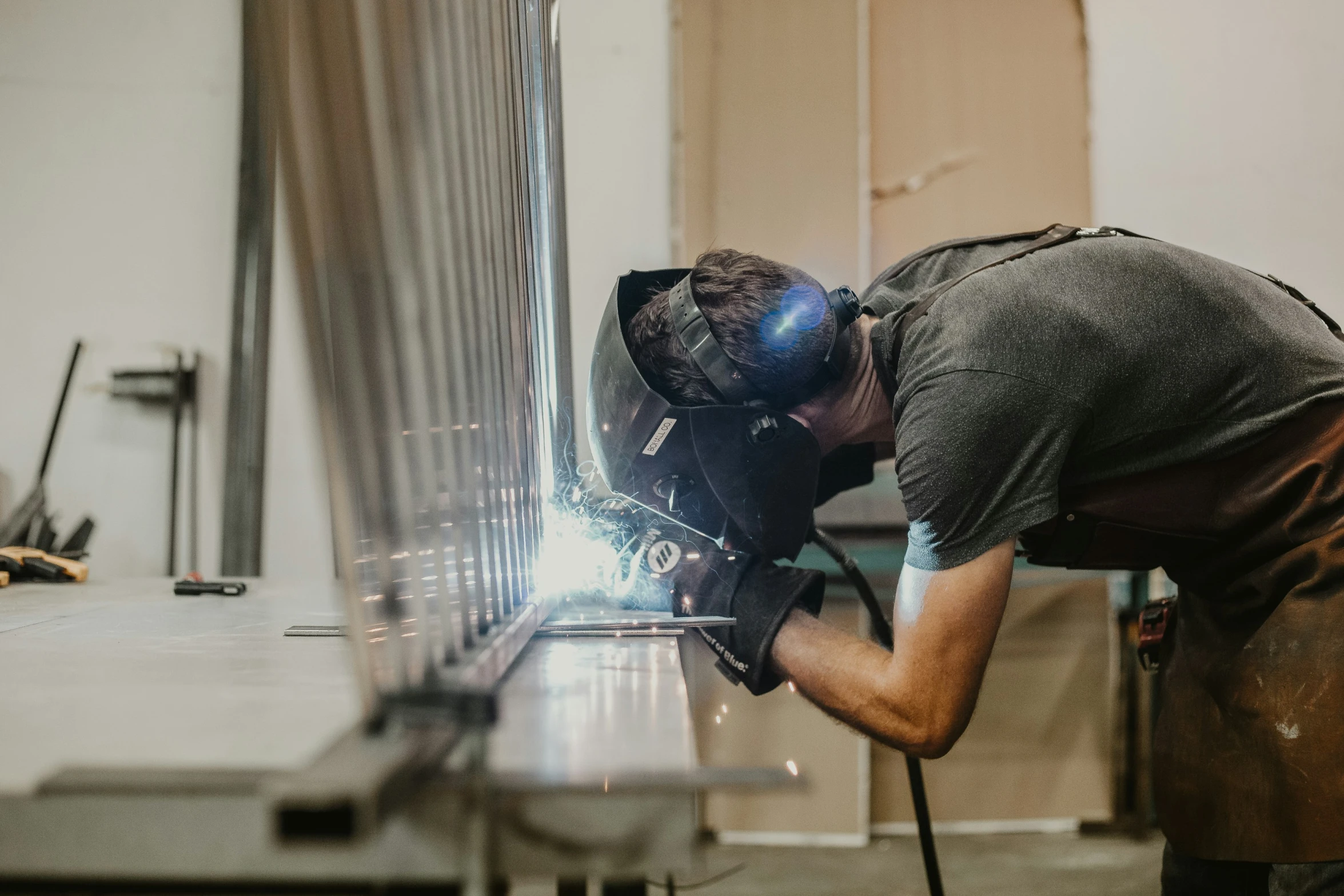 a welder with glasses welding in an workshop