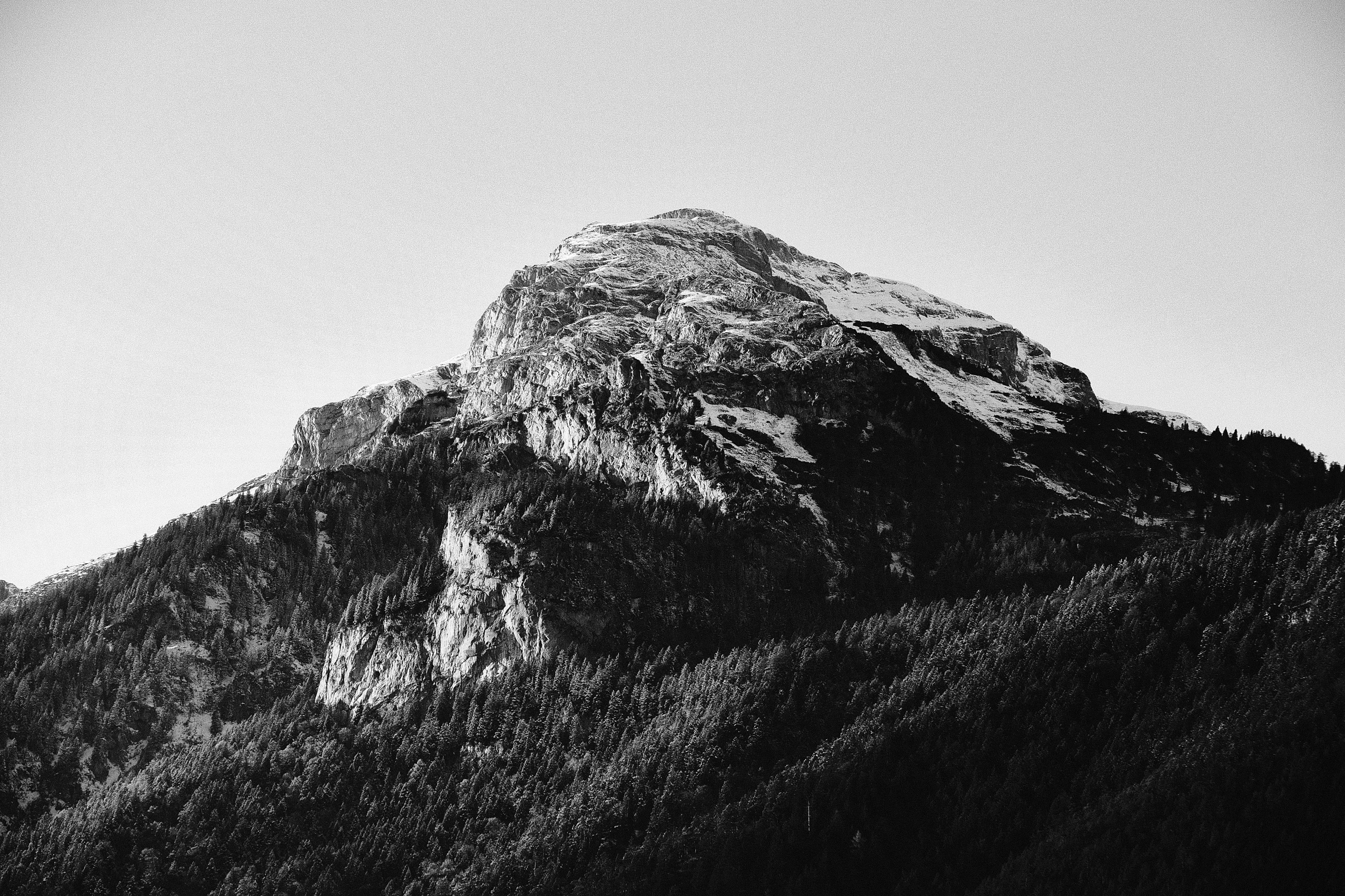 a large mountain covered in snow under a clear sky