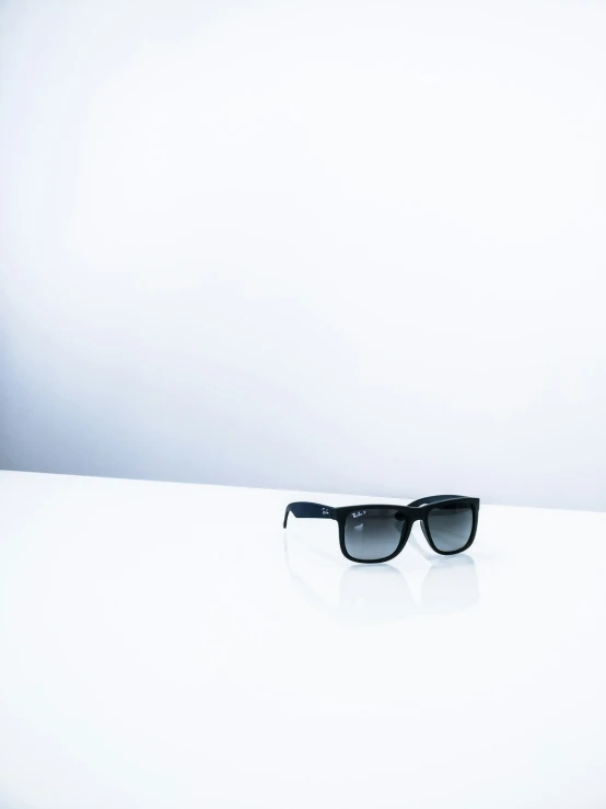 black sunglasses sitting on a white surface on the table