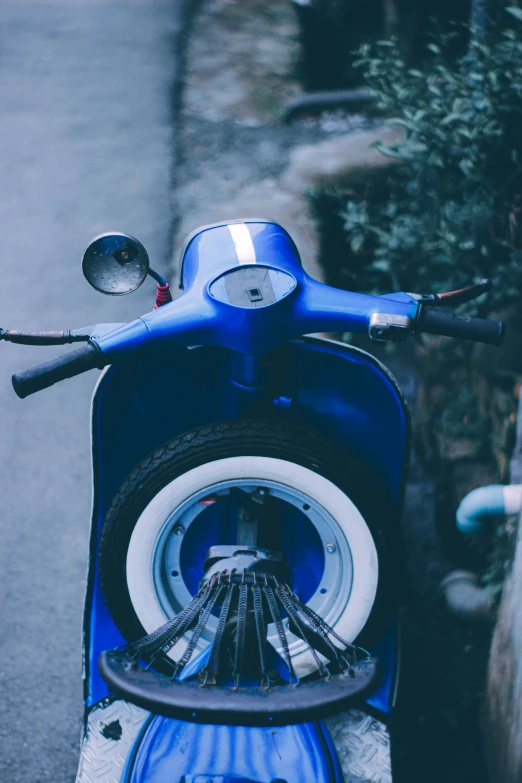 the small motor scooter is parked on the side of the road