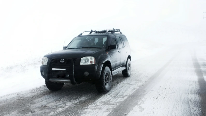 a black suv is parked in the snow