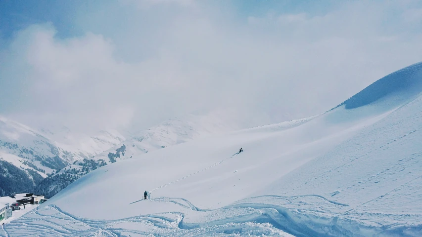 two people on skis on a snow covered mountain