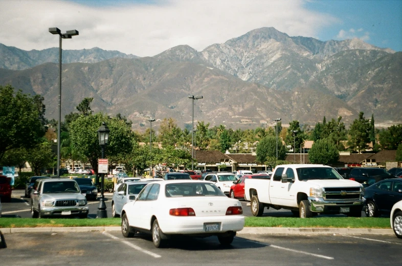 a number of cars in a parking lot near mountains