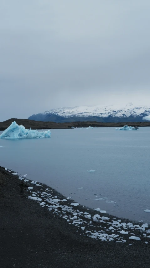 a lake with icebergs and snow covered mountains