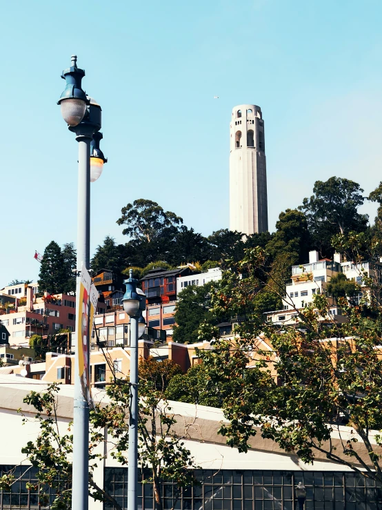 a street light sits in the foreground as an old city tower stands in the background