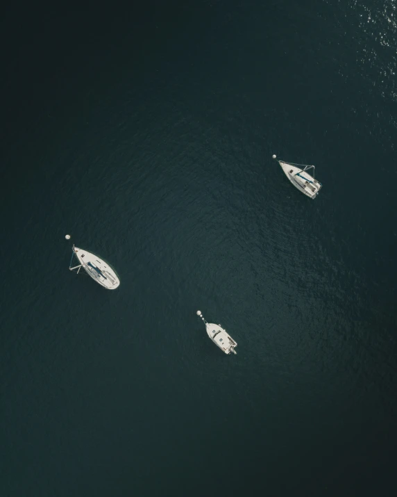 a few boats floating in the water near a shoreline