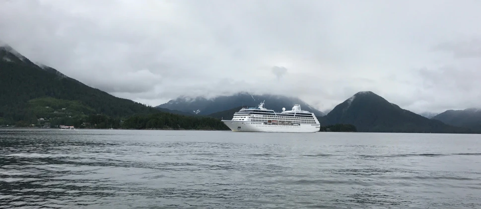 the cruise ship sails on a calm, rainy day