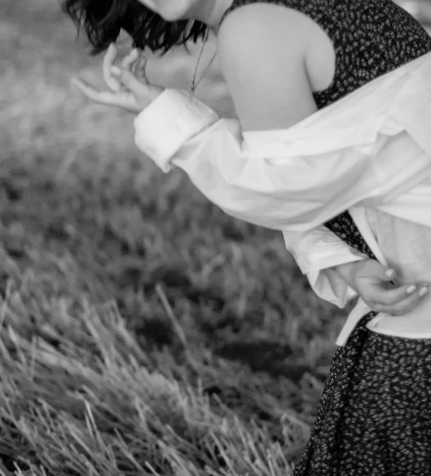 a beautiful woman holding onto her dress outside