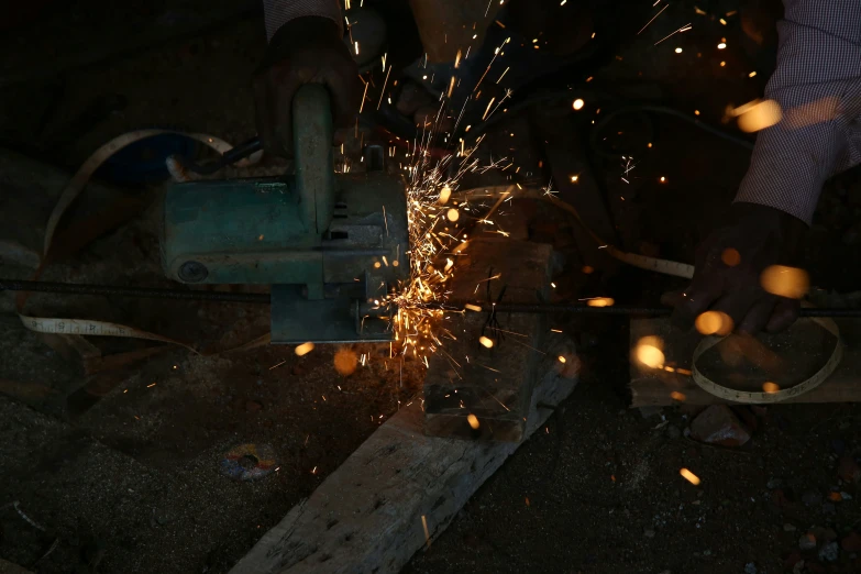 a person is grinding metal on a wooden beam