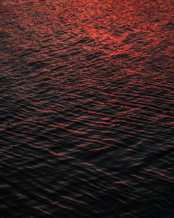 some red and yellow water at sunset with ripples