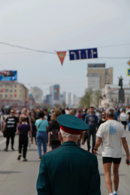 a man in a green hat walking down the street