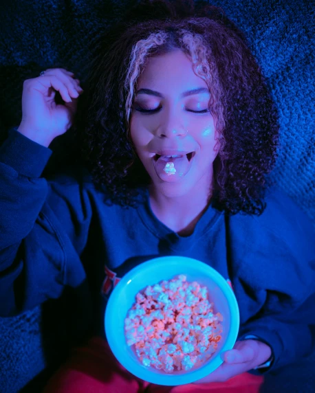 a girl in blue sweater with a bowl of cereal