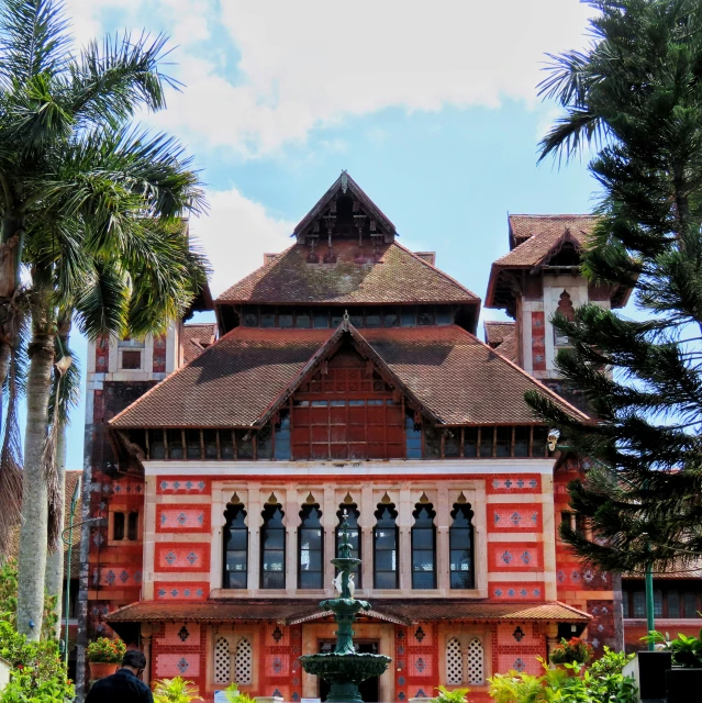 a large red brick building with windows and many plants