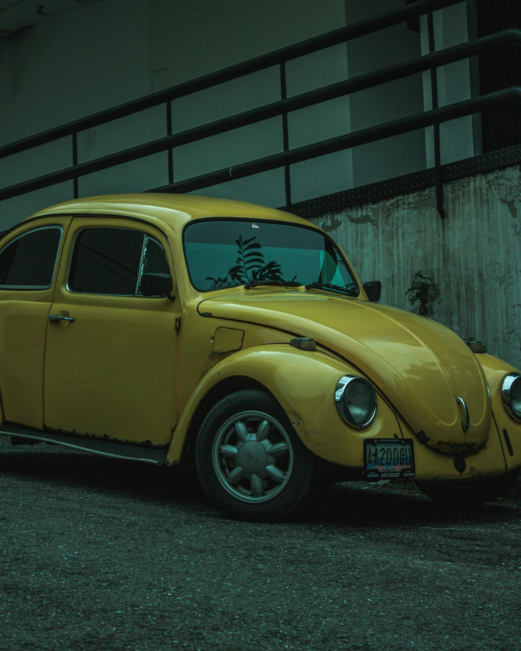 the old vw bug is parked on the street