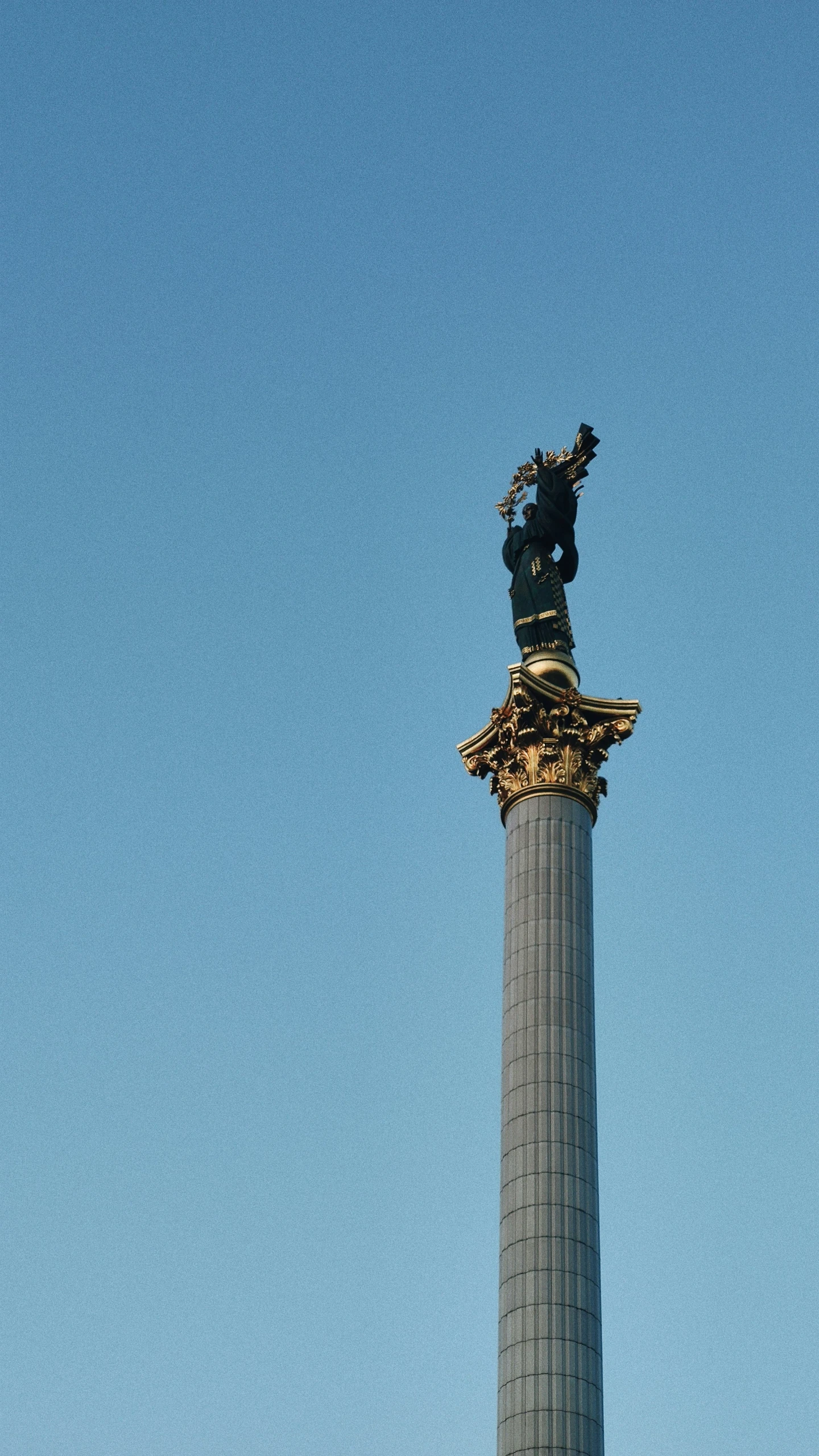 a tall gray column with a gold sculpture at the top