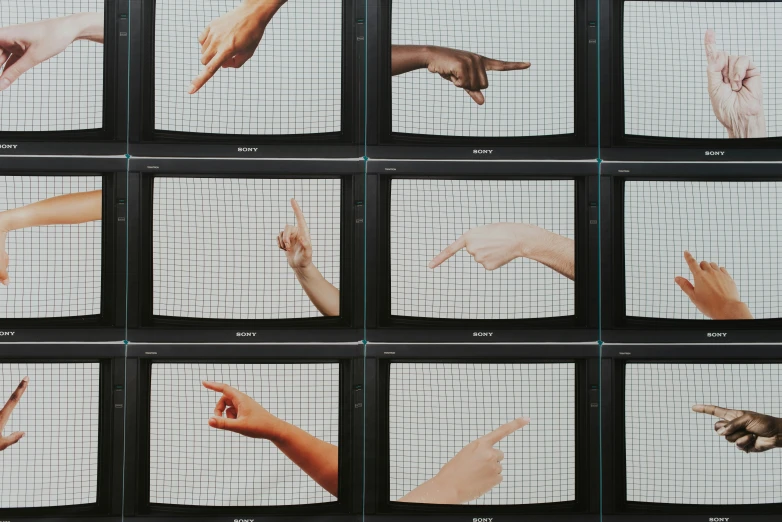 multiple hands pointing toward each other across white grids