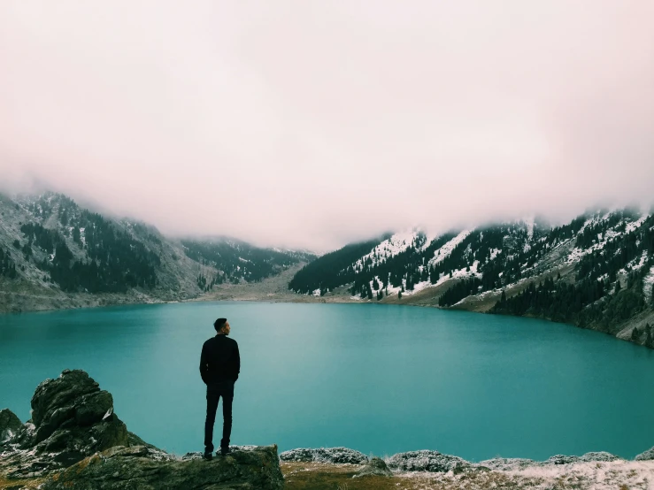 a person standing on top of a large hill looking at the ocean