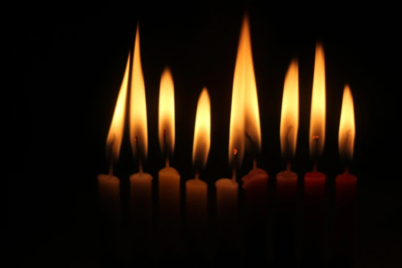 several candles with orange lights are lit in a dark room