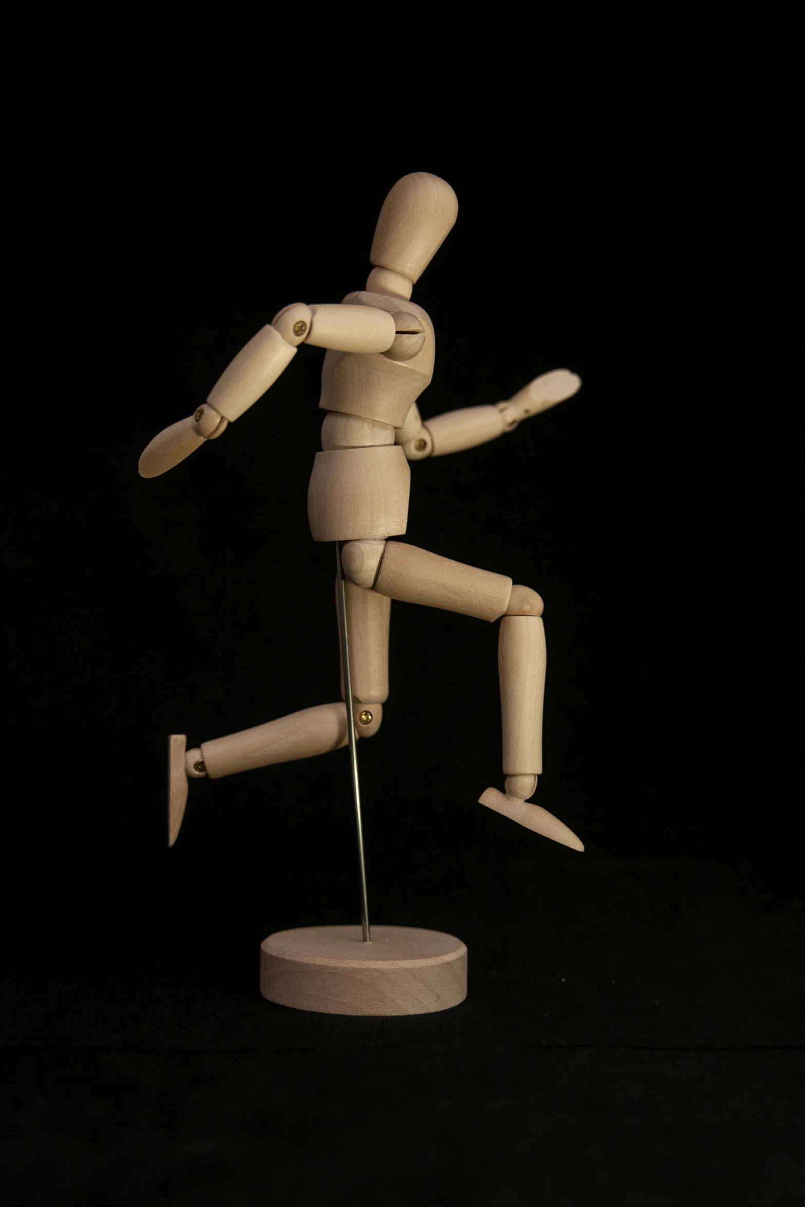 a dummy holding a small stick standing on a base
