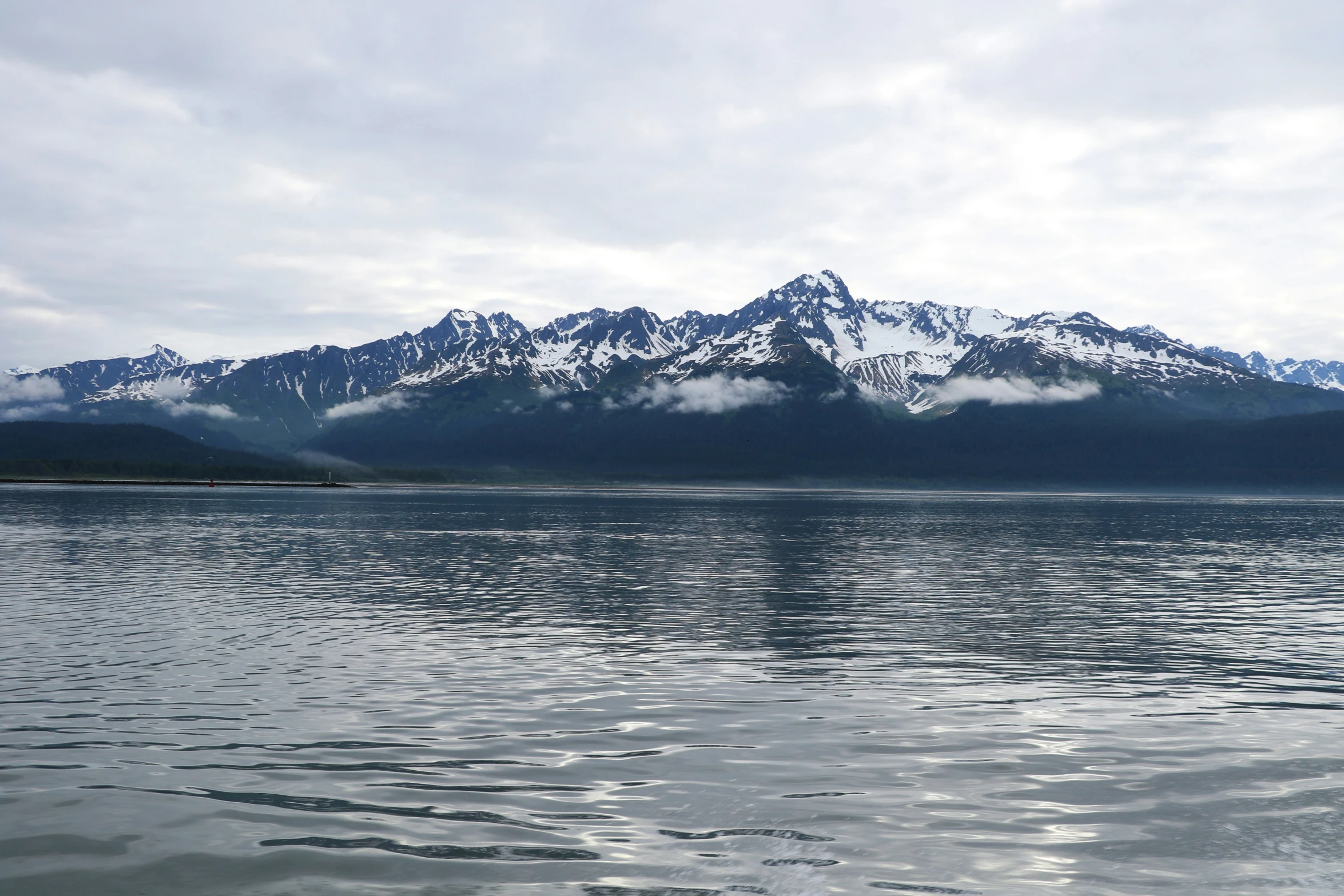 the view from across the water towards a mountain range